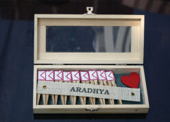 wooden box with pegs and mail box icon on them with name tag