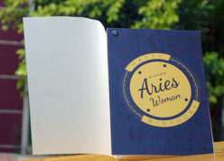 Aries woman printed horoscope greeting card opened on a wooden table