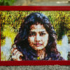 Red a3 size frame with mosaic photos printed on it placed on a small concrete stones