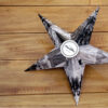 Black and White star with pictures of a girl printed over it on a wooden table.