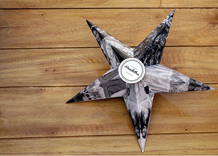 Black and White star with pictures of a girl printed over it on a wooden table.
