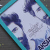 Turquoise green frame of half face for half birthday on a brown sheet with confetti and color flags.