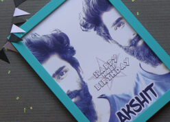 Turquoise green frame of half face for half birthday on a brown sheet with confetti and color flags.