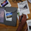 book spread open and photos with text with person holding a pen