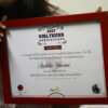 girl holding a red frame containing her photo and name