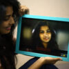 surprised girl looking at her less pixels photo frame in a room