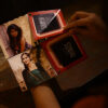 girl opening the handmade greeting card with ring handle containing photos and names