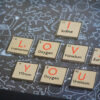 close up picture of i love you in chemical forumlae on wooden pieces inside a frame