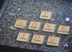 close up picture of i love you in chemical forumlae on wooden pieces inside a frame