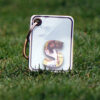 A key chain with stack of letter leaves with S letter with a girl's picture on the first leaf.