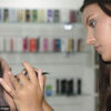 girl applying make up to the bridal in a beauty parlour