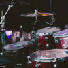 Maroon color drum set arranged for a live show of a rock band.