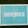 white a4 size frame placed on bed top with deepika name and love symbols edited in it