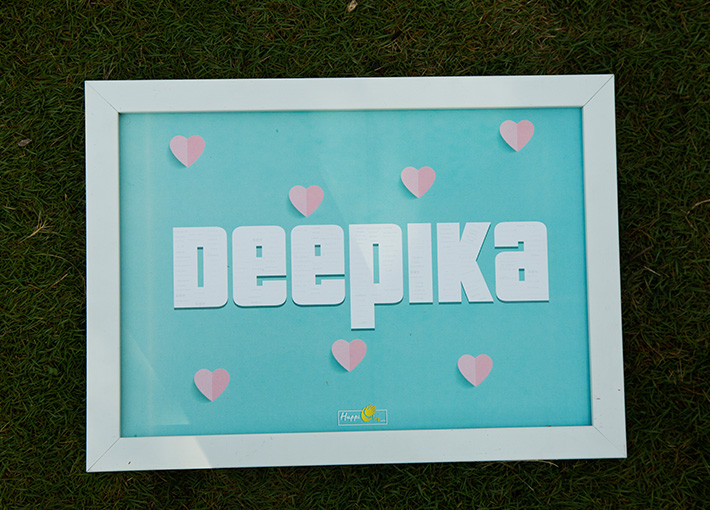 white a4 size frame placed on bed top with deepika name and love symbols edited in it