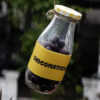 chocolate bottle hanging to a thread with yellow sticker having chocomatics sticker