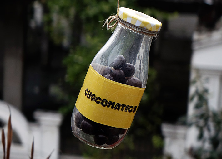 chocolate bottle hanging to a thread with yellow sticker having chocomatics sticker