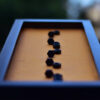 Close view of name in nuts and bolts in an orange background black frame