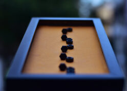 Close view of name in nuts and bolts in an orange background black frame