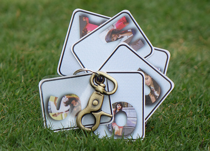 circular spread of picture letter key chain on grass.
