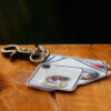 Vintage style key holder to a key chain with pictures and letters of a name on a wooden table.