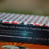 Details of playing cards in sarcastic manner on a side of custom card box