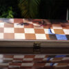 girl's half face on wooden chess board placed on shiny table