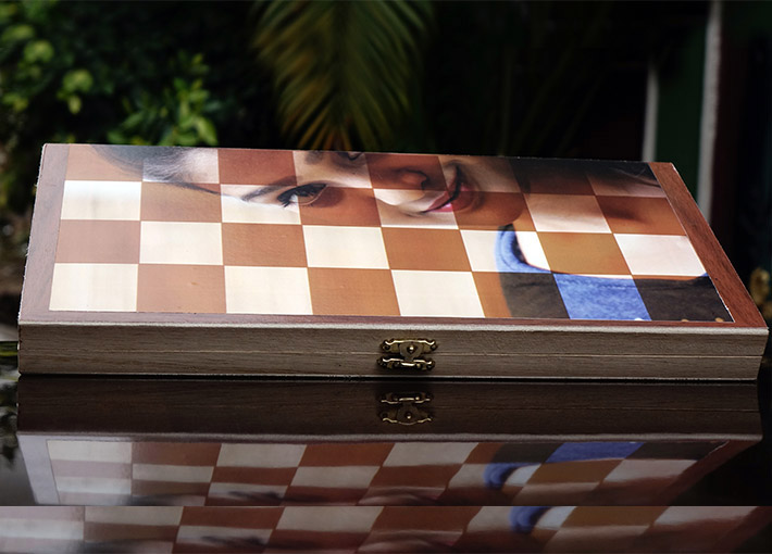 girl's half face on wooden chess board placed on shiny table
